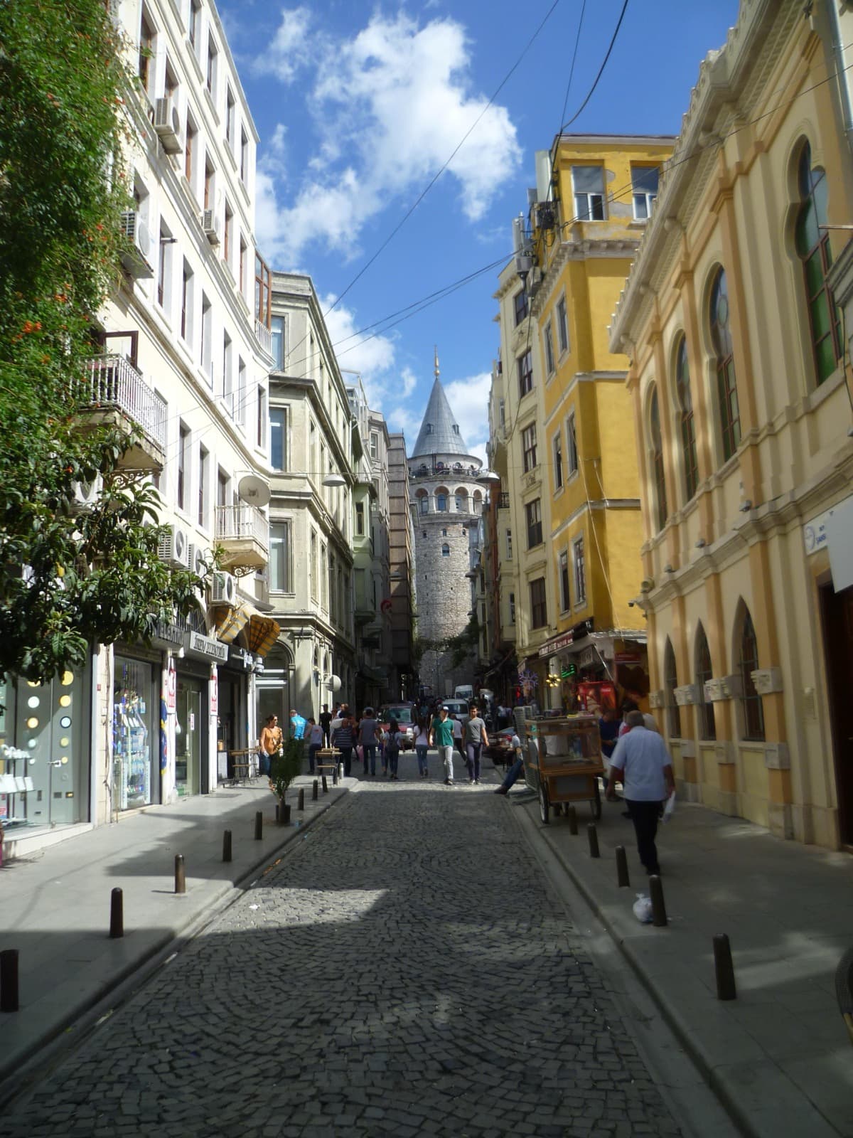 Galata Tower rising above the shops and cobbles of Buyuk Hendek Street in Beyoglu
