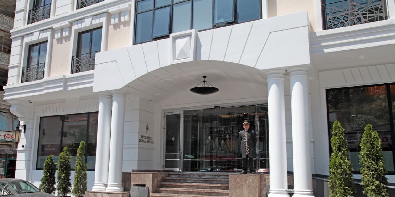 White stone facade and columned entrance of Hotel Dora Istanbul on Dolapdere Caddesi