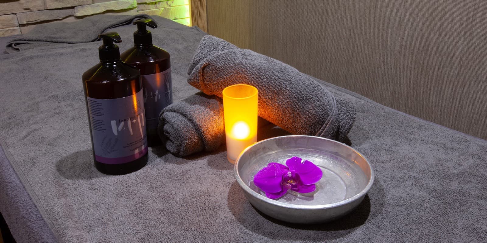 Massage table with rolled towels, oils and a candle in the Hotel Dora Istanbul spa