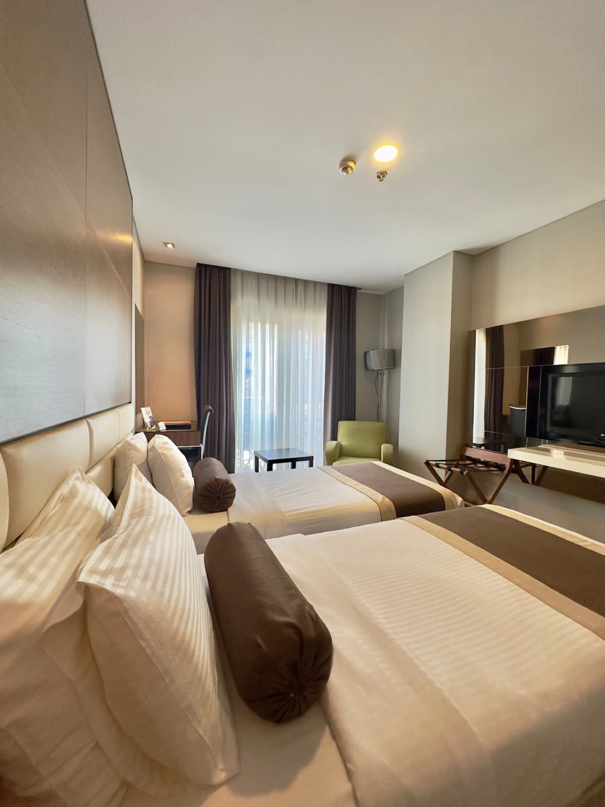 Superior twin room at Hotel Dora Istanbul with two beds, a desk and a green armchair